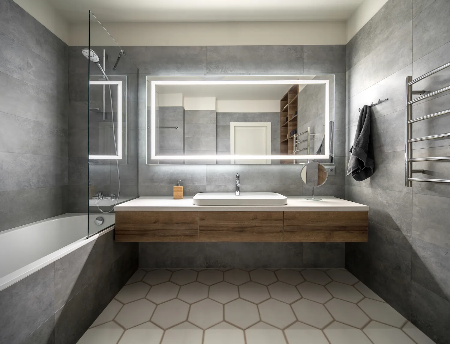 Grey-tiled bathroom with backlit mirror