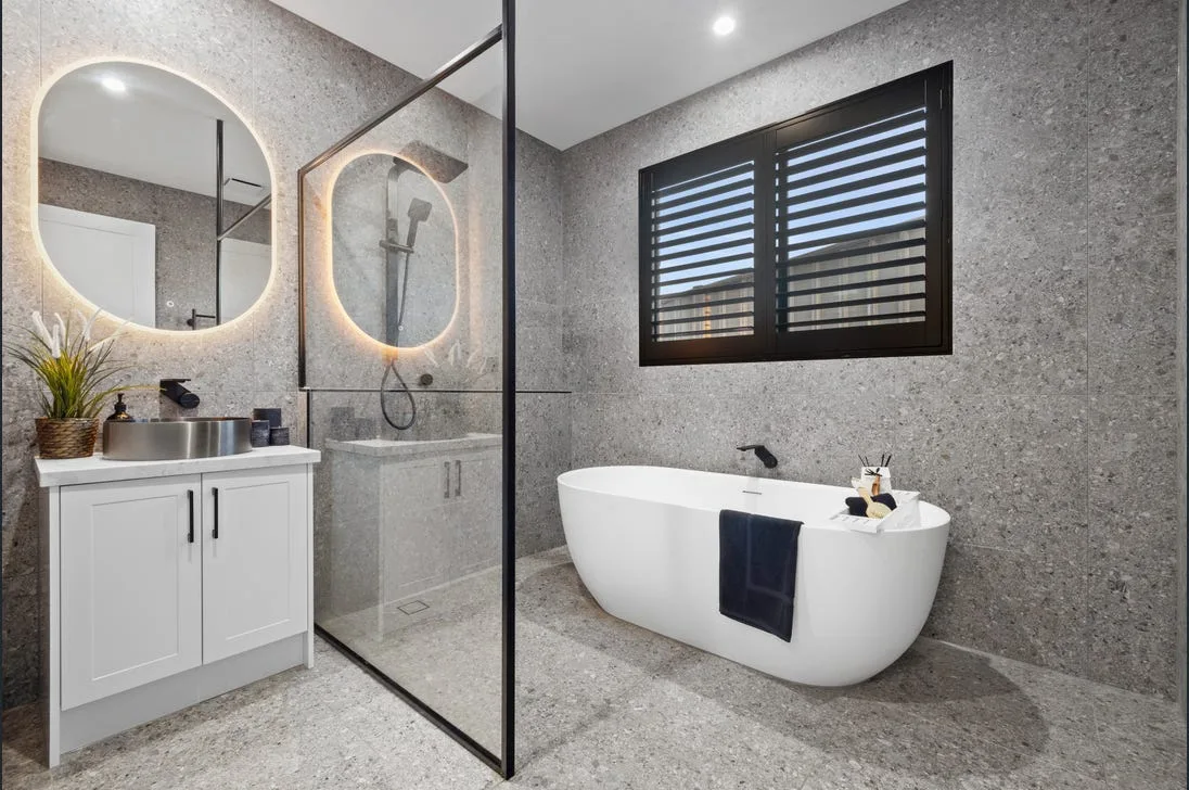 Bathroom with freestanding bath and black-framed shower