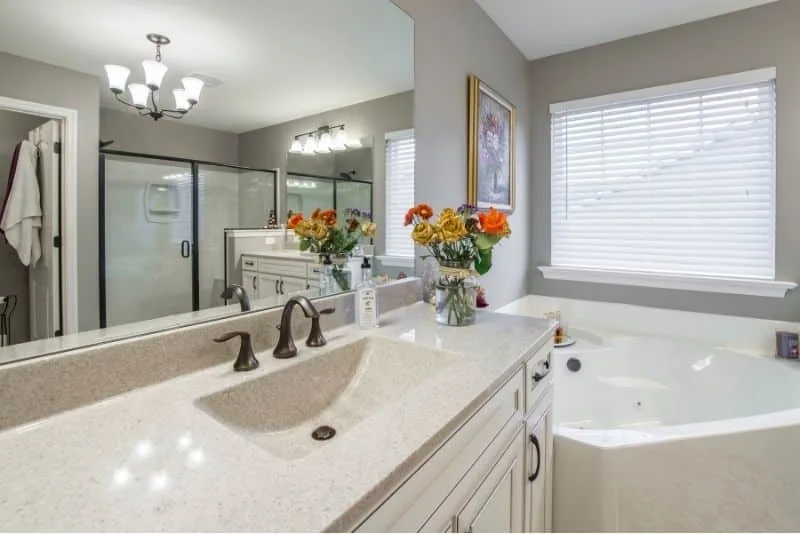Bathroom vanity beside a corner spa bath